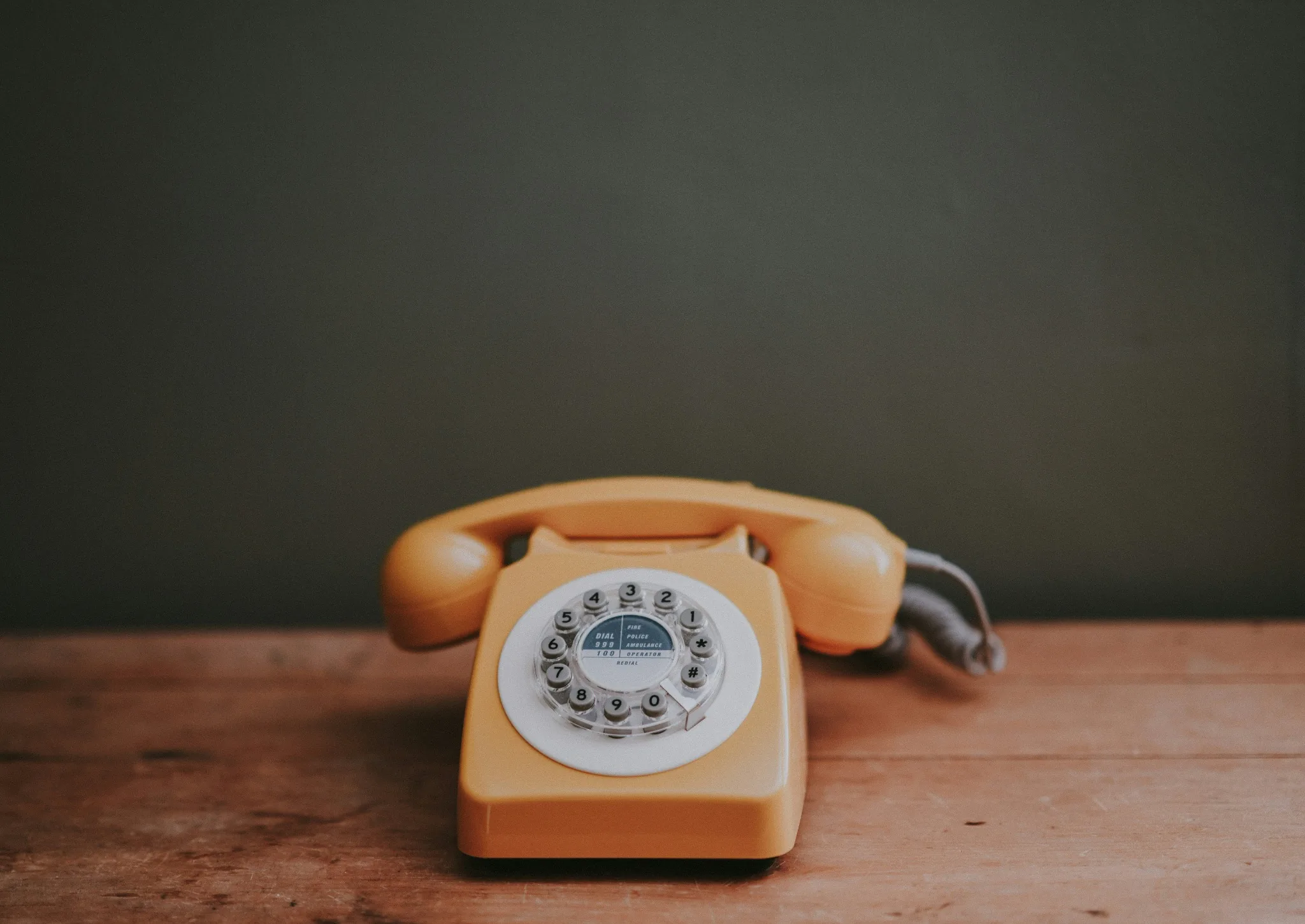 Vintage rotary telephone on a wooden desk
